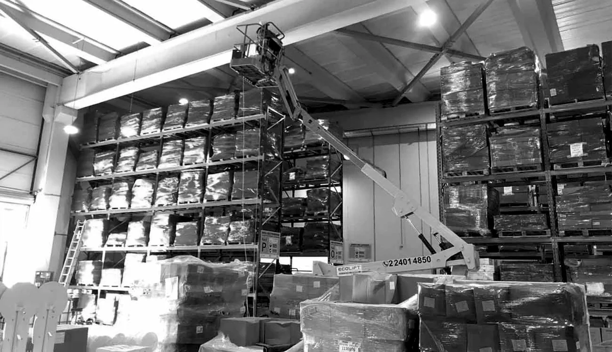 Trabajo de instalación técnica en altura dentro de una bodega industrial